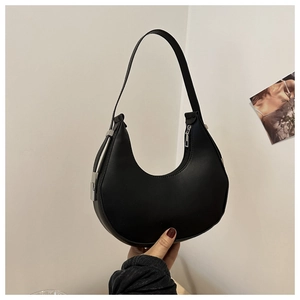 Detail of minimalist black hobo shoulder bag featuring matte leather and silver hardware