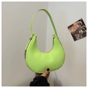 Detail of neon green half-moon underarm bag with silver buckle and smooth leather finish
