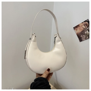 Detail of a white minimalist hobo shoulder bag featuring smooth leather and silver hardware