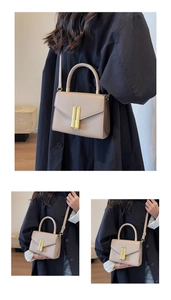 Detail of khaki pebbled leather handbag with gold metal clasp and adjustable strap
