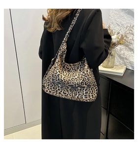 Side view of large leopard print tote bag worn over the shoulder by a model