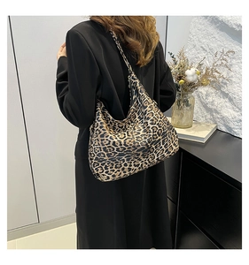 Close-up of leopard print tote bag worn over the shoulder showing soft fabric texture