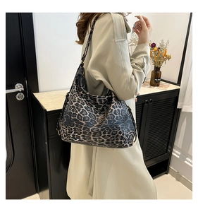 Detailed view of the large leopard print bucket bag with adjustable metal buckle on strap