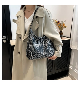 Detailed view of fashionable leopard print tote bag styled with a beige trench coat
