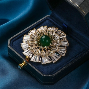 Exquisite gold floral brooch with emerald green stone and baguette-cut zircon crystals