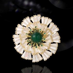 Radial floral brooch with green malachite stone and sparkling crystal petals on gold