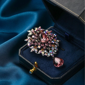 Vintage silver brooch with pear-shaped purple gemstone and colorful rhinestones in a blue box