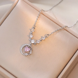 Collier avec pendentif lune en argent et cœur en zircon rose sur boîte à bijoux