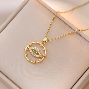 Gold Bohemian evil eye necklace with green stone and white zircon on elegant jewelry box