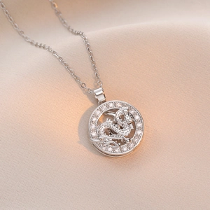 Collier pendentif dragon argenté orné de zircons cubiques sur fond de tissu en soie