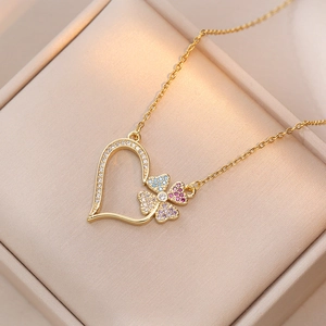 Collier doré avec pendentif cœur et trèfle coloré serti de strass sur boîte à bijoux