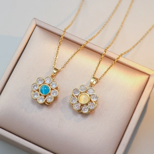 Detailed shot of gold sunflower pendants with sparkling blue and yellow crystals on chain