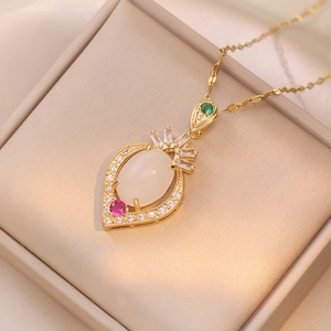 Elegant gold necklace with leaf pendant featuring emerald green and pink gemstones