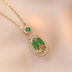 Detail of gold necklace with oval green gemstone pendant and pink floral accents
