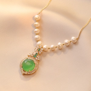 Luxurious emerald zircon and freshwater pearl necklace on champagne silk background