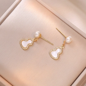Elegant gold gourd drop earrings with freshwater pearl and shell inlay on velvet
