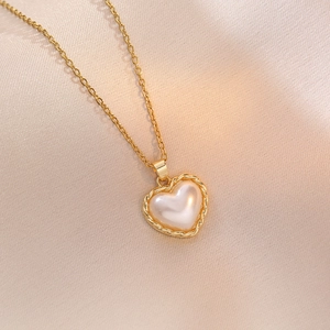 Collana in acciaio al titanio dorato con pendente a cuore di perla su raso champagne