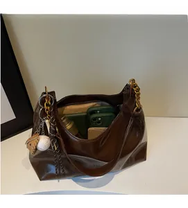 Large capacity dark brown glossy tote bag showing spacious interior and golden chain strap