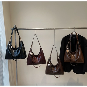 Detail of multi-color high-gloss Hobo bags with metallic chain and charm on display