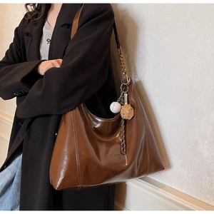 Deep brown patent leather tote bag with glossy finish and cute bear charm pendant