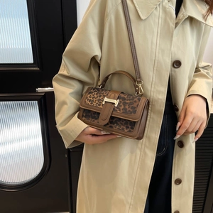 Chic leopard print crossbody bag with H-buckle and adjustable brown strap on model
