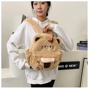 Detail eines khakifarbenen Plüschbären-Rucksacks mit 3D-Ohren und Pfotenstickerei