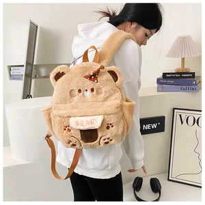 Detail eines süßen Plüschbären-Rucksacks mit Teddy-Ohren und BEAR-Stickerei auf der Klappe