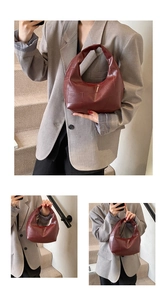 Macro shot of dark red hobo bag with geometric stitching and glossy leather texture