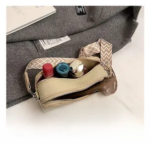 Internal capacity of beige pebbled leather camera bag with jacquard strap showing phone and makeup