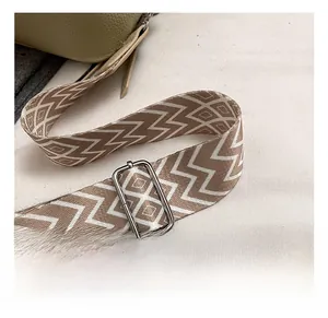 Detail of adjustable woven shoulder strap with geometric pattern and silver metal buckle