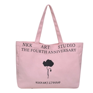 Pink canvas tote bag with floral print and NKK ART STUDIO text on a white background