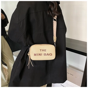 Detail of beige mini camera bag with brown logo text and jacquard woven strap