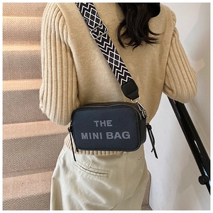 Detail view of the black mini bag with geometric strap and The Mini Bag lettering