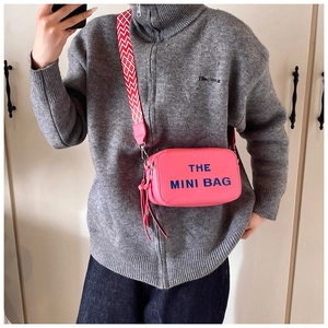 Detail of pink mini bag with geometric strap and The Mini Bag text in mirror selfie