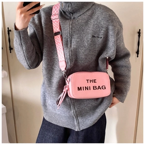 Pink lychee leather mini crossbody bag with wide geometric strap and fringe detail