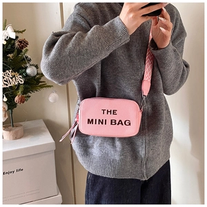 Pink pebbled leather mini camera bag with wide woven strap and block letter print