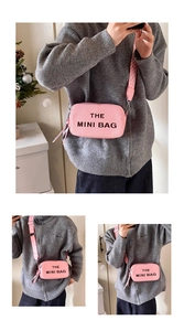 Pink mini crossbody bag with embossed letters and patterned wide strap on a model