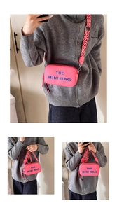 Detail of rose red mini crossbody bag with wide geometric strap and text printing