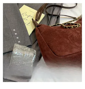 Sac cabas en daim marron avec chaîne dorée et bandoulière en cuir au style citadin