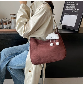Détail du sac cabas en daim bordeaux avec breloque nuage blanc et bandoulière chaîne