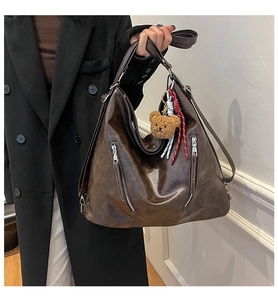 Détails du grand sac cabas marron foncé avec fermetures éclair argentées et breloque ours