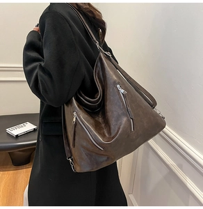 Détail du sac Hobo vintage marron foncé avec deux fermetures éclair argentées décoratives