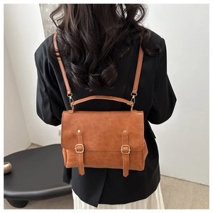 Vintage brown leather backpack and handbag for women with metallic buckles on a model