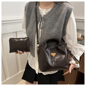 Detail of dark brown vintage oil wax leather tote with small pouch and metal logo