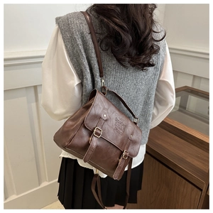 Detail of vintage dark brown leather bag showing textured PU material and buckle
