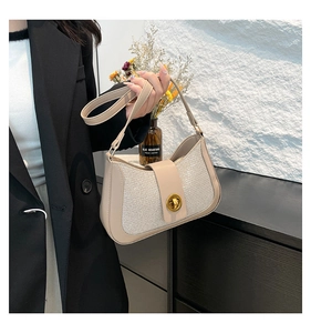 Detail of beige woven texture shoulder bag with golden round twist lock and leather strap