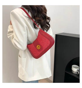 Red tweed and leather underarm bag with gold lock shown on model shoulder