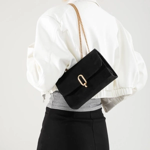 Elegant black matte suede crossbody bag with gold chain strap and metal clasp buckle