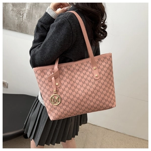 Detail of pink tote bag with M-letter print and golden circular metal charm
