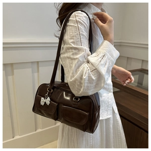 Detail der dunkelbraunen Vintage-Achseltasche mit Hochglanzfinish und Silberbogen